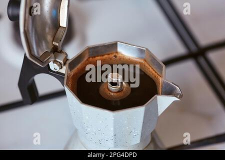 Eine Geysir-Kaffeemaschine auf einem Gasherd produziert eine Portion Kaffee Stockfoto