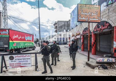 Nablus, Palästina. 20. März 2023. Israelische Soldaten patrouillieren mitten in der Stadt Hawara nach einem Schussanschlag auf das Auto eines jüdischen Siedlers in der Stadt südlich von Nablus im besetzten Westjordanland. Die israelische Armee schloss alle Handelsgeschäfte in der Stadt Hawara und entsandte ihre Streitkräfte durchgehend. Kredit: SOPA Images Limited/Alamy Live News Stockfoto