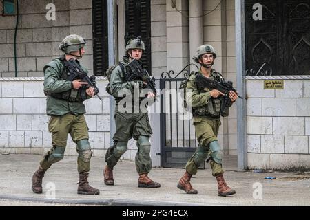 Nablus, Palästina. 20. März 2023. Israelische Soldaten patrouillieren mitten in der Stadt Hawara nach einem Schussanschlag auf das Auto eines jüdischen Siedlers in der Stadt südlich von Nablus im besetzten Westjordanland. Die israelische Armee schloss alle Handelsgeschäfte in der Stadt Hawara und entsandte ihre Streitkräfte durchgehend. Kredit: SOPA Images Limited/Alamy Live News Stockfoto