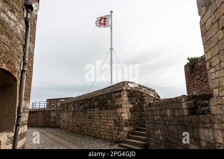Die offizielle englische Kulturerbe-Flagge über den Dealburg-Zinnen gegenüber dem Ärmelkanal von Dealit in Kent, Großbritannien. Das Schloss wurde von König erbaut Stockfoto