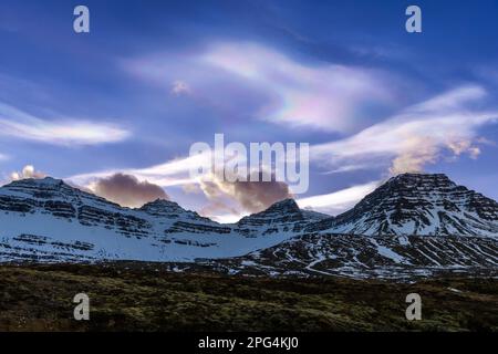 Farbenfrohe polare, stratosphärische, nacreöse Eiswolken über den Bergen von Faskrudsfjordur, Fáskrúðsfjörður Fjord, Island Stockfoto