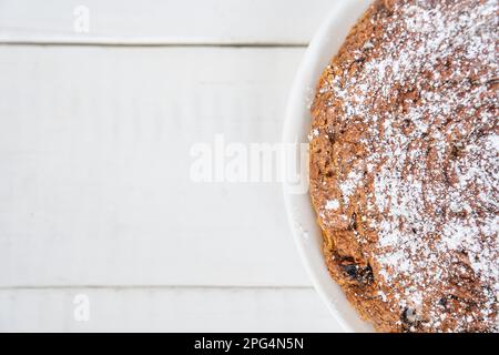 Draufsicht eines Stücks Karotten- und Rosinenkuchen. Der Kuchen ist glutenfrei, Milch- und eifrei. Selektiver Fokus, Platz für Text. Diät-Dessert. Das Konzept der gesunden Ernährung. Hochwertiges Foto Stockfoto