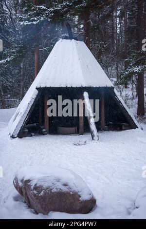 Im Winter gibt es im Naturschutzgebiet Aulanko einen Lagerfeuer im Tipi-Stil (kota). Hameenlinna, Finnland. 23. Februar 2023. Stockfoto