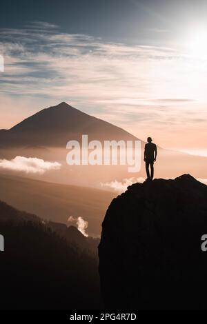 Una persona observando el pico Teide a contraluz al atardecer desde un mirador. En la isla de tenerife. Stockfoto