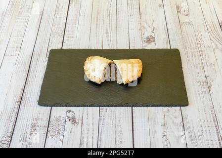 Die Empanada ist ein Teig, der mit Fleisch, Gemüse oder Obst gefüllt ist und in Öl oder Fett gebacken oder gebraten wird. Sein Name kommt vom kastilischen Empanar Stockfoto