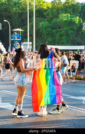 Eine Gruppe von Freunden, die im Pride mit der stolzen Flagge gekleidet sind. Sonniger Sommertag, Frauen für Freiheit und Gleichheit. Stockfoto