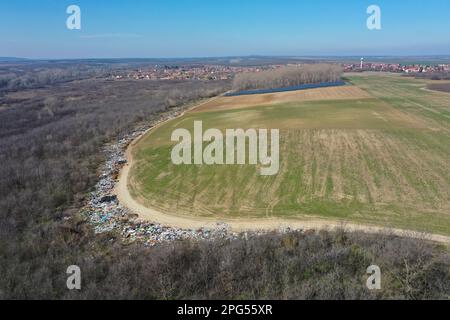 Erstaunliche Umweltverschmutzung in Ungarn. In der Nähe einer Stadt liegt eine Menge Müll neben einer unbefestigten Straße an der Grenze. Umweltverschmutzung. Illegales Dumping. Stockfoto