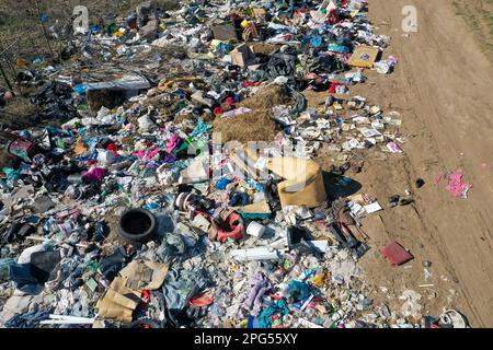 Erstaunliche Umweltverschmutzung in Ungarn. In der Nähe einer Stadt liegt eine Menge Müll neben einer unbefestigten Straße an der Grenze. Umweltverschmutzung. Illegales Dumping. Stockfoto