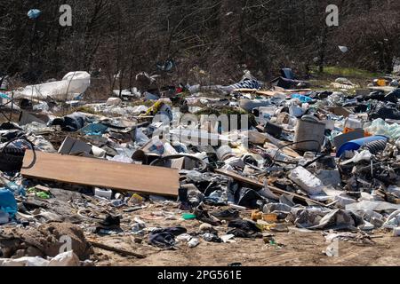 Erstaunliche Umweltverschmutzung in Ungarn. In der Nähe einer Stadt liegt eine Menge Müll neben einer unbefestigten Straße an der Grenze. Umweltverschmutzung. Illegales Dumping. Stockfoto