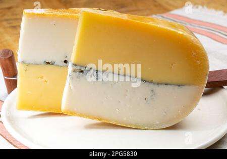 Farbenfroher doppelter holländischer Käse, Hartkäse aus Kuhmilch und Ziegenmilch mit schwarzer Schimmelschicht im Inneren, Nahaufnahme Stockfoto