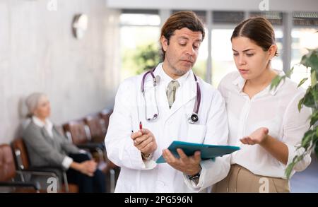 Aufmerksamer Arzt verschreibt Tests an Patienten der Klinik, um den Gesundheitszustand zu überprüfen Stockfoto