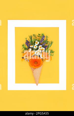 Abstrakte surreale, sommerliche essbare Blumen und frische Kräuter in Eiswaffel mit weißem Rahmen. Minimales Naturspaß-Konzept auf kräftigem Gelb. Stockfoto