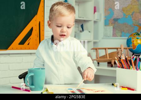 Bildungsprozess. Hausstudium. Lern- und Bildungskonzept. Nach dem Unterricht. Süßes Kind im Alter von 3 Jahren im Klassenzimmer in der Nähe der Tafel. Stockfoto