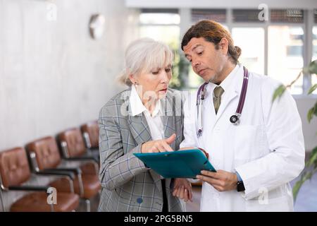 Aufmerksamer Arzt verschreibt Tests an Patienten der Klinik, um den Gesundheitszustand zu überprüfen Stockfoto