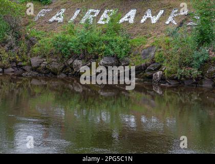 Fairbanks, Alaska, USA - 27. Juli 2011: Der Name der Stadt wird durch weiße Steine am grünen Ufer des Chena River in der Innenstadt deutlich Stockfoto