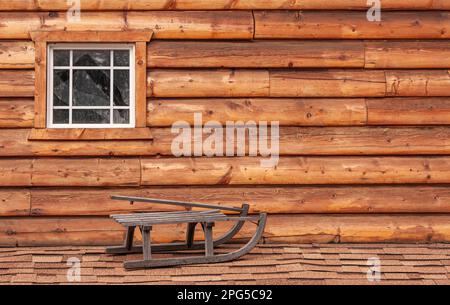 Fairbanks, Alaska, USA - 27. Juli 2011: Pike's Waterfront Lodges. Kleiner Schlitten aus Holz vor brauner Holzwand Stockfoto