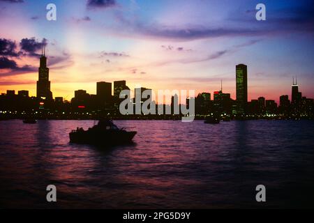 DIE SKYLINE VON 1980S LIEGT AM SONNENUNTERGANG AM LAKE MICHIGAN IM VORDERGRUND CHICAGO ILLINOIS USA - KR63595 TRA001 HARS DREAMS GRUNDSTÜCK MIT DRAMATISCHEN, AUFREGENDEN IMMOBILIENSTRUKTUREN STÄDTE DÄMMERUNGSGEBÄUDE ILLINOIS SEEN IM VORDERGRUND IL LAKE MICHIGAN WOLKENKRATZER IM MITTLEREN WESTEN DER ALTEN MODE Stockfoto