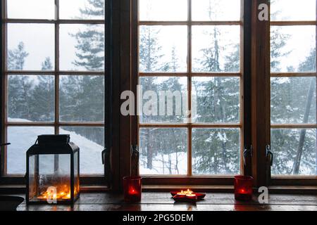 Aus einem Fenster in einer abgelegenen Hütte in einem verschneiten Wald in Norwegen Stockfoto