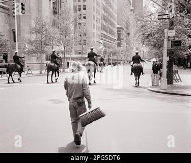 1970S MANN STRASSENKEHRER, DER MIT BESEN AUFRÄUMT, FOLGT NACH DER PARADE DER BERITTENEN POLIZEI-PFERDEDIVISION NEW YORK CITY USA - P8140 HAR001 JOBS IN DER HARS-GESCHICHTE VEREINIGTE STAATEN KOPIEREN RAUM VOLLE LÄNGE PERSONEN BESEN VEREINIGTE STAATEN VON AMERIKA MÄNNER TRANSPORT B&W SKILLS OCCUPATION SKILLS SÄUGETIERE ARBEITEN NACH NYC-BESETZUNG VON HINTER NEW YORK CITIES IN DER DIVISION NACH HINTEN EASTSIDE INFRASTRUKTUR NEW YORK CITY SANITATION ANGESTELLTER HAUSMEISTER RÜCKBLICK SÄUGETIERE MITTE ERWACHSENER MANN IN SCHWARZ-WEISS FIFTH AVENUE HAR001 ALTE PARADEN Stockfoto