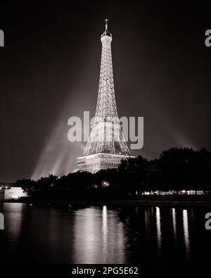 1960S DER EIFFELTURM PARIS BEI NACHT SPIEGELT SICH IN DER SEINE WIDER FRANKREICH - R19066 HAR001 HARS SYMBOLE EUROPE B&W EIFFELTURM TRAUMBAU-ABENTEUER EUROPEAN PROPERTY WORLD'S EXTERIEUR BELEUCHTET 1889 PRIDE IMMOBILIENKONZEPT GITTER WORLD'S FAIR KONZEPTIONELLE STRUKTUREN SEINE KULTURDENKMAL GUSTAVE EIFFEL CHAMP CHAMP DE MARS SYMBOLISCHER ALEXANDRE GUSTAVE EIFFEL ERBAUTE KONZEPTE MARS NACHT REFLEKTIERT TOURISTEN ATTRAKTION SCHMIEDETER SCHWARZ-WEISSER EIFFELTURM HAR001 IKONISCHES WAHRZEICHEN BELEUCHTET ALTMODISCHE PARISER POSTERIZED-REPRÄSENTATION Stockfoto