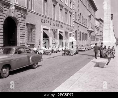 1950S MÄNNER, FRAUEN SITZEN IM CAFÉ AM STRASSENRAND UND TEENAGER SITZEN AUF EINER BANK AUF DER VIA DELLA CONCILIAZIONE VATIKANSTADT ROM ITALIEN - R5668 MAY001 HARS FREUNDSCHAFT DAMEN PERSONEN AUTO MÄNNLICH TEENAGER TRANSPORT MOPED B&W CAFE UND AUTOS ÄUSSERE ITALIEN AUTOS JUGENDLICHE FAHRZEUGE VATIKAN ROLLER DELLA JUGENDLICHE MITTLERE ERWACHSENE MÄNNER MITTLERE ERWACHSENE FRAUEN MOTORRADENTSPANNUNG ZUSAMMENSEIN ÜBER SCHWARZ UND WEISS-KAUKASISCHE ETHNISCHE ZUGEHÖRIGKEIT, ALTMODISCHES ROM Stockfoto