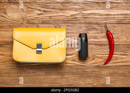 Beutel mit Spray und Pfeffer auf Holzhintergrund Stockfoto