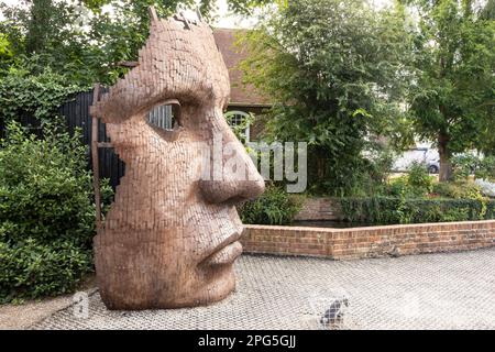 The Face Mask oder Bulkhead Art von Rick Kirby , britischer Bildhauer, der vor dem Marlowe Theatre in der Stadt Canterbury, Kent UK sitzt. Stockfoto