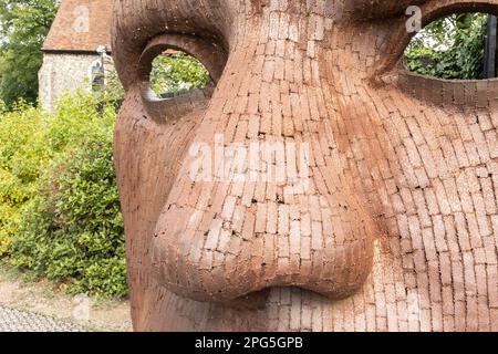 The Face Mask oder Bulkhead Art von Rick Kirby , britischer Bildhauer, der vor dem Marlowe Theatre in der Stadt Canterbury, Kent UK sitzt. Stockfoto