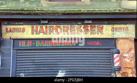 Altes verwittertes Barbier-Shop-Schild auf rotem Sandsteingebäude Stockfoto