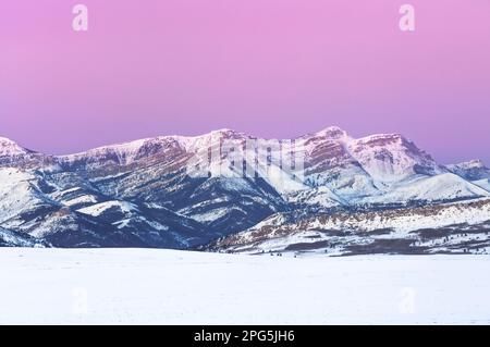 Im Winter bei augusta, montana, erstrahlt der Himmel vor Sonnenaufgang über dem Dampferberg an der felsigen Bergfront Stockfoto