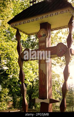 Borsec, Harghita County, Rumänien, 2002. Geformtes hölzernes Kruzifix vor der christlich-orthodoxen Kirche, ein historisches Denkmal aus dem Jahr 1847. Stockfoto