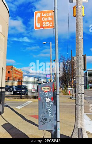 Münzbetriebenes öffentliches Telefon mit einem orangefarbenen „Ortsgespräche 25 Cent“-Schild in Cleveland, Ohio, USA, am 24. Februar 2023. Stockfoto