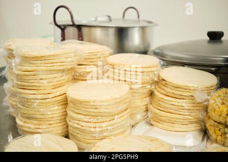 Pakete mit frisch zubereiteten, traditionellen Arepas, die auf einem kolumbianischen Markt verkauft werden können. Stockfoto