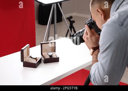 Professioneller Fotograf, der im Studio teure Armbanduhren fotografiert, konzentriert sich auf Zubehör Stockfoto