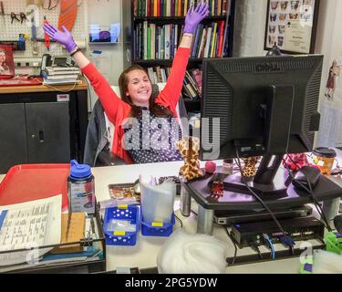 Eine junge Frau feiert in ihrem Büro Stockfoto