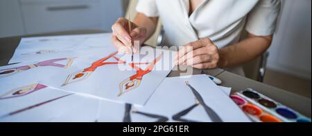 Eine gesichtslose Frau zeichnet Aquarelle von Sportbekleidung. Nahaufnahme der Hände eines Modedesigners. Stockfoto