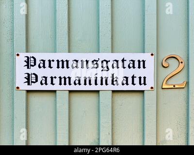 Zweisprachiges Straßenschild auf Holzfassade, Holzhaus, Straßenname Parmansgatan auf Schwedisch und Finnisch, Hausnummer 2, Altstadt von Kristinestad Stockfoto