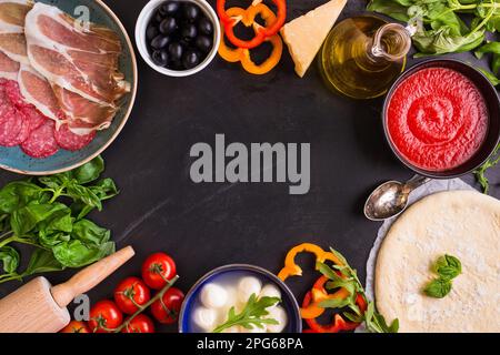 Pizza mit verschiedenen Belägen und Zutaten. Platz für Text. Pizza, Mehl, Käse, Tomaten, Basilikum, Peperoni, Pilze und Walznadel Stockfoto