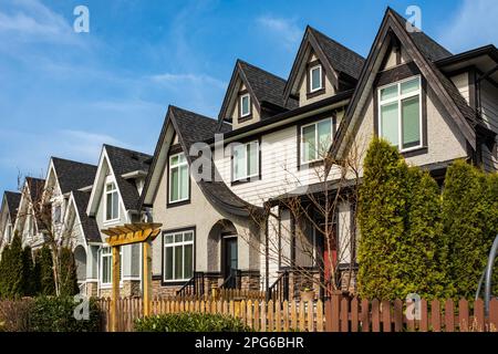 Brandneue, gehobene Stadthäuser in einem kanadischen Viertel. Schöne Stadthäuser. Außenfassade einer Reihe farbenfroher moderner Stadthäuser. Stockfoto