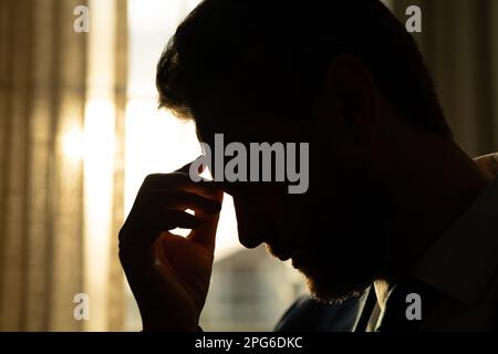 Müde, Kopfschmerzen und Augenbelastung vom Notebook. Geschäftsmann mit Stress, Burnout und Ermüdungsaugen. Ein Geschäftsmann, der müde Augen nach dem Computer reibt Stockfoto