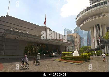 Fassade des ehemaligen Clifford Pier, jetzt Teil des Fullerton Bay Hotels, mit dem OUE Drehturm auf der rechten Seite und der Marina Bay Skyline im Hintergrund Stockfoto