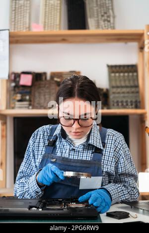 Reparatur eines zerlegten Laptops. Analyse-Computer-RAM-Speicher durch Lupe. Stockfoto