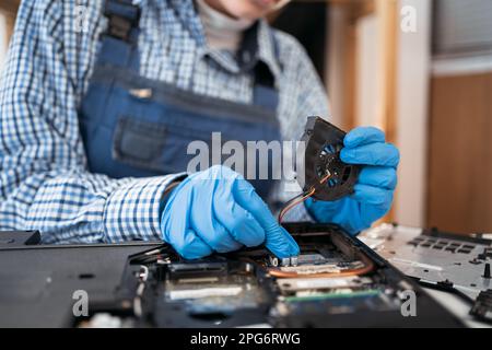 Befestigen, Zerlegen und Reinigen des Laptop-Kühlsystems. Staub und Schmutz auf dem Computerlüfter. Stockfoto