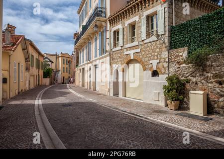 Gewundene Kopfsteinpflasterstraße in der französischen Altstadt (Le Suquet) von Cannes. Stockfoto