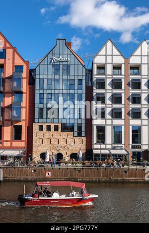 Danzig, Polen, Radisson Hotel and Suites auf Granary Island und Boot auf dem Motlawa River. Stockfoto