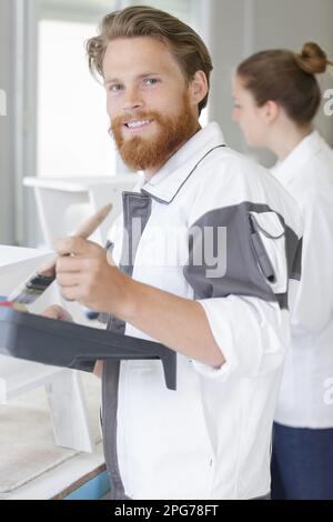 Glücklicher junger Arbeiter, der in die Kamera schaut Stockfoto