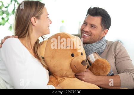 Liebevoller Freund gibt Teddybär an aufgeregte Freundin Stockfoto