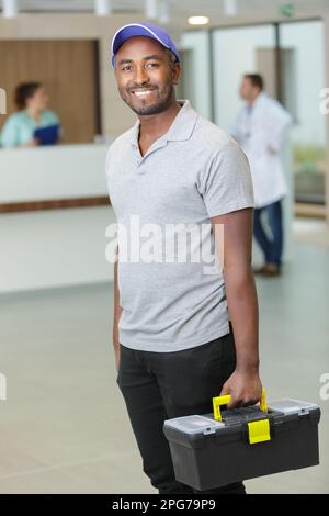 Glücklicher Elektriker oder Hausmeister in der Klinik Stockfoto