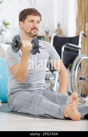 Mann im Fitnessstudio und hebe schwere Kurzhanteln Stockfoto