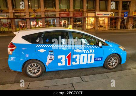 Wien, Österreich - 19. August 2022: Taxi in der Nacht die Straße entlang. Stockfoto